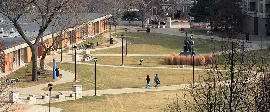 Two people walking around the University Commons