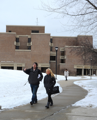 Two students walk a path on the University Commons in winter