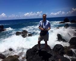 Honors Program Coordinator Jon Hageman standing on a rocky seaside