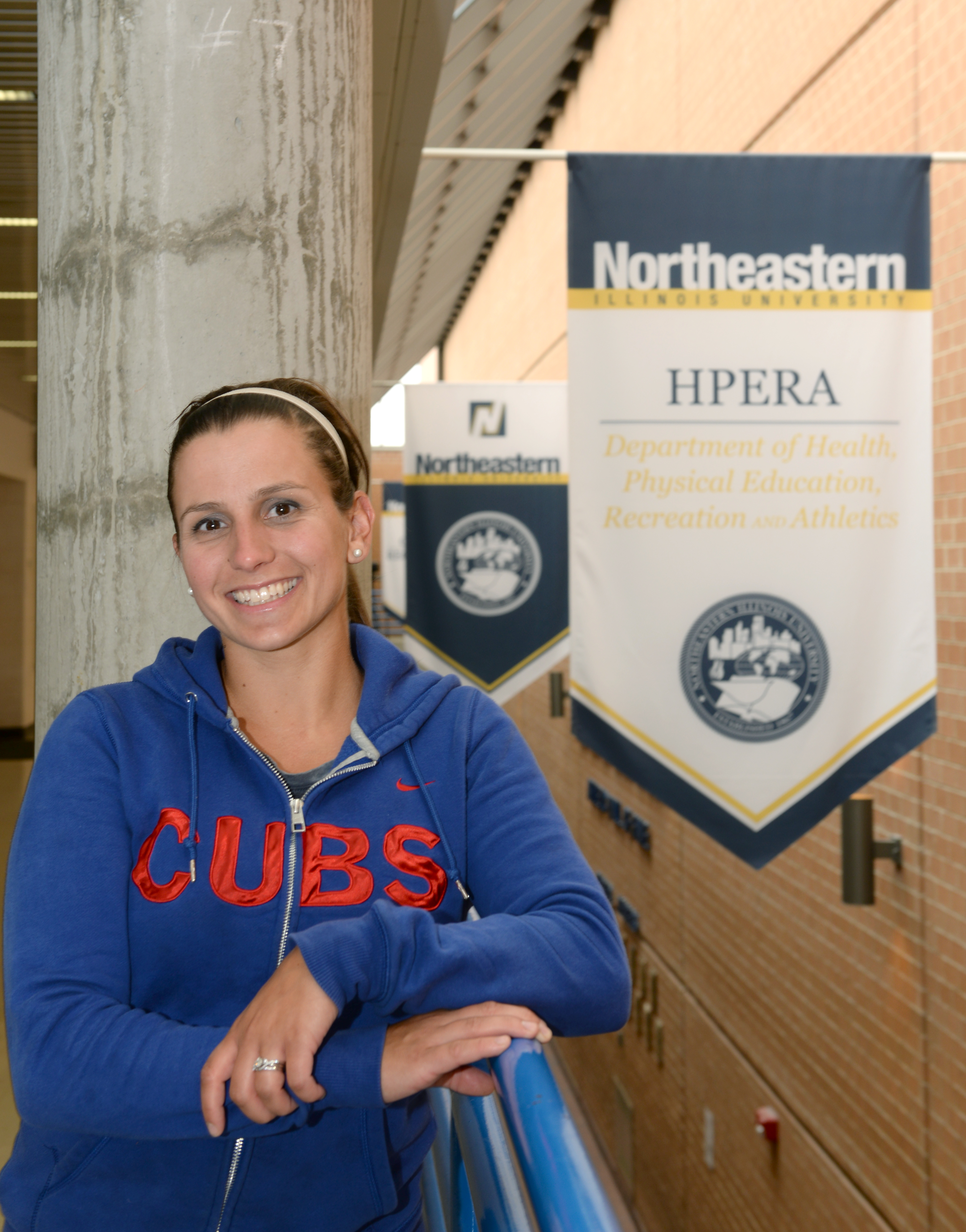 Gina Ridge, Fall 2015 NEIUAA Internship Scholarship recipient, poses in front of two Northeastern signs.