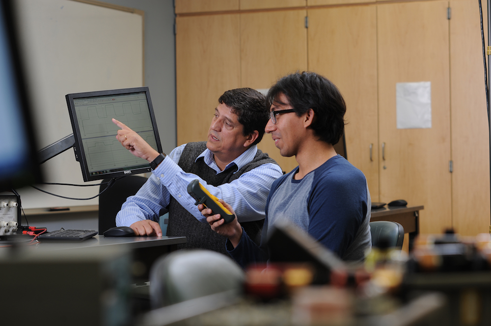 Professor of Physics Paulo Acioli (right) and student Cesar Bustos work together in a laboratory setting