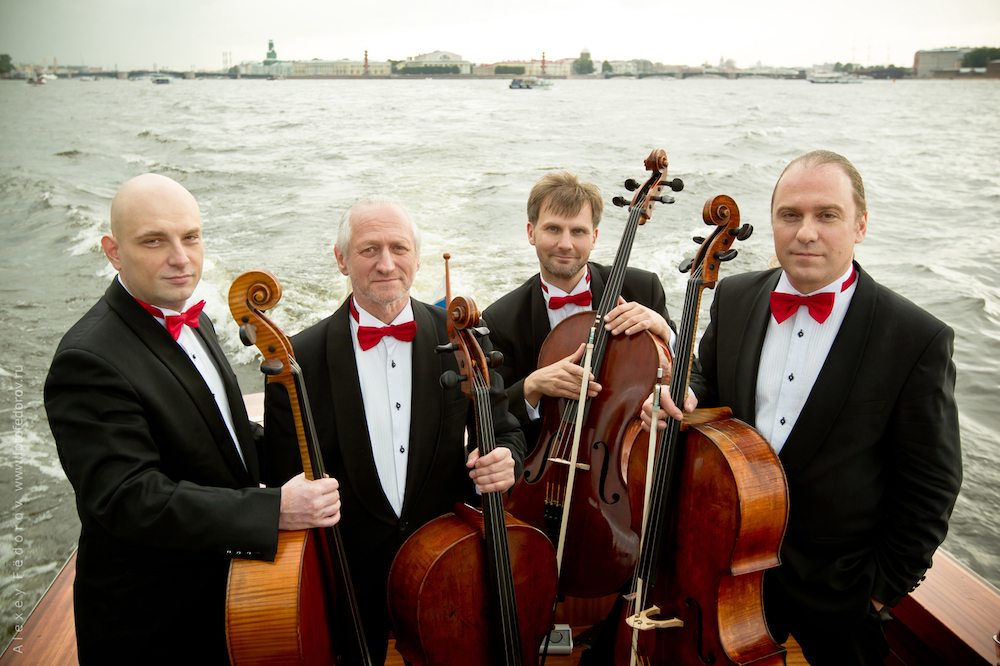 The members of the Rastrelli Cello Quartet pose with their instruments on a boat