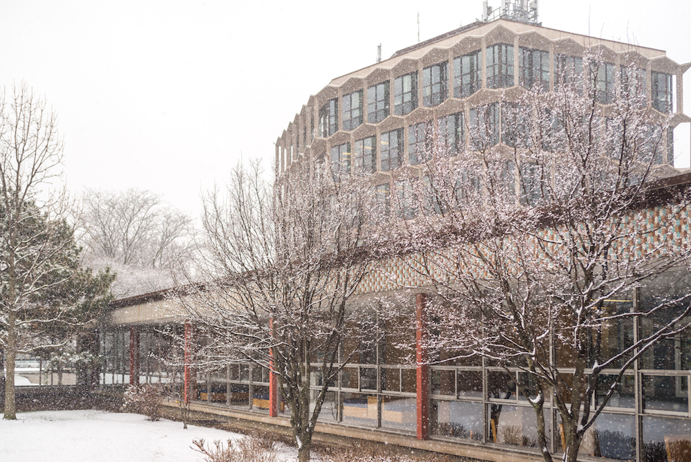 Snow falls in front of the Sachs Administration Building.