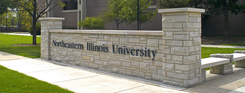 A low exterior, decorative wall bears the words Northeastern Illinois University