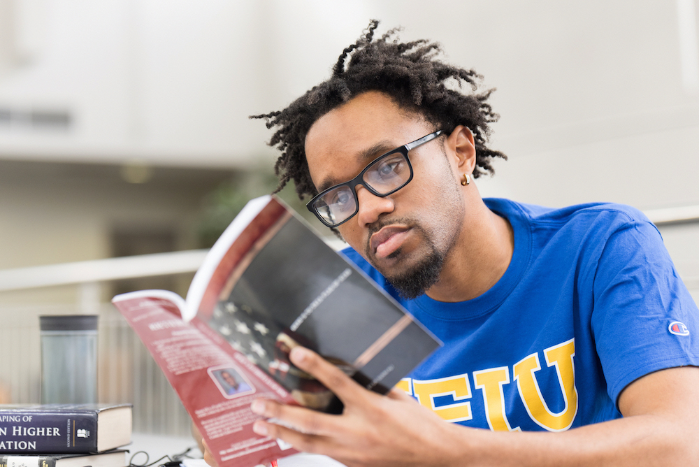 Graduate student Byron Terry reading a book
