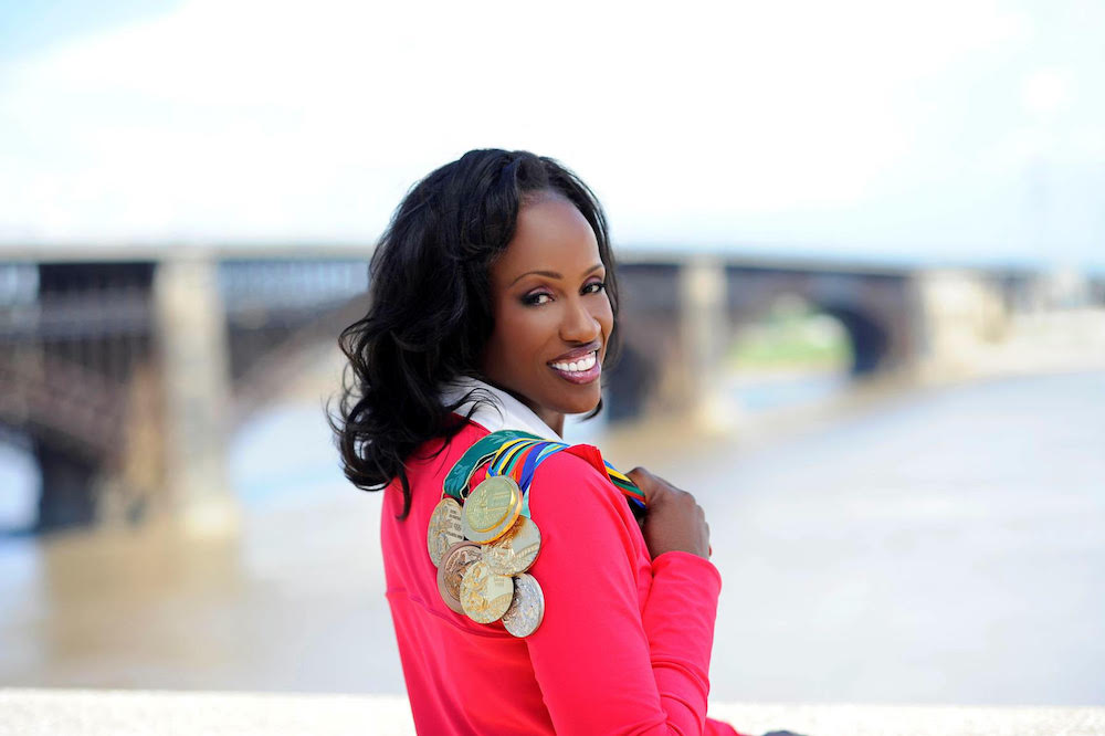 Jackie Joyner-Kersee looks back over her shoulder over which is draped her many Olympic medals