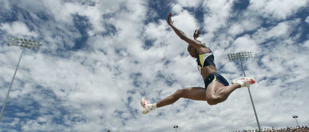 Jackie Joyner-Kersee in mid-air during a long jump as seen from below 