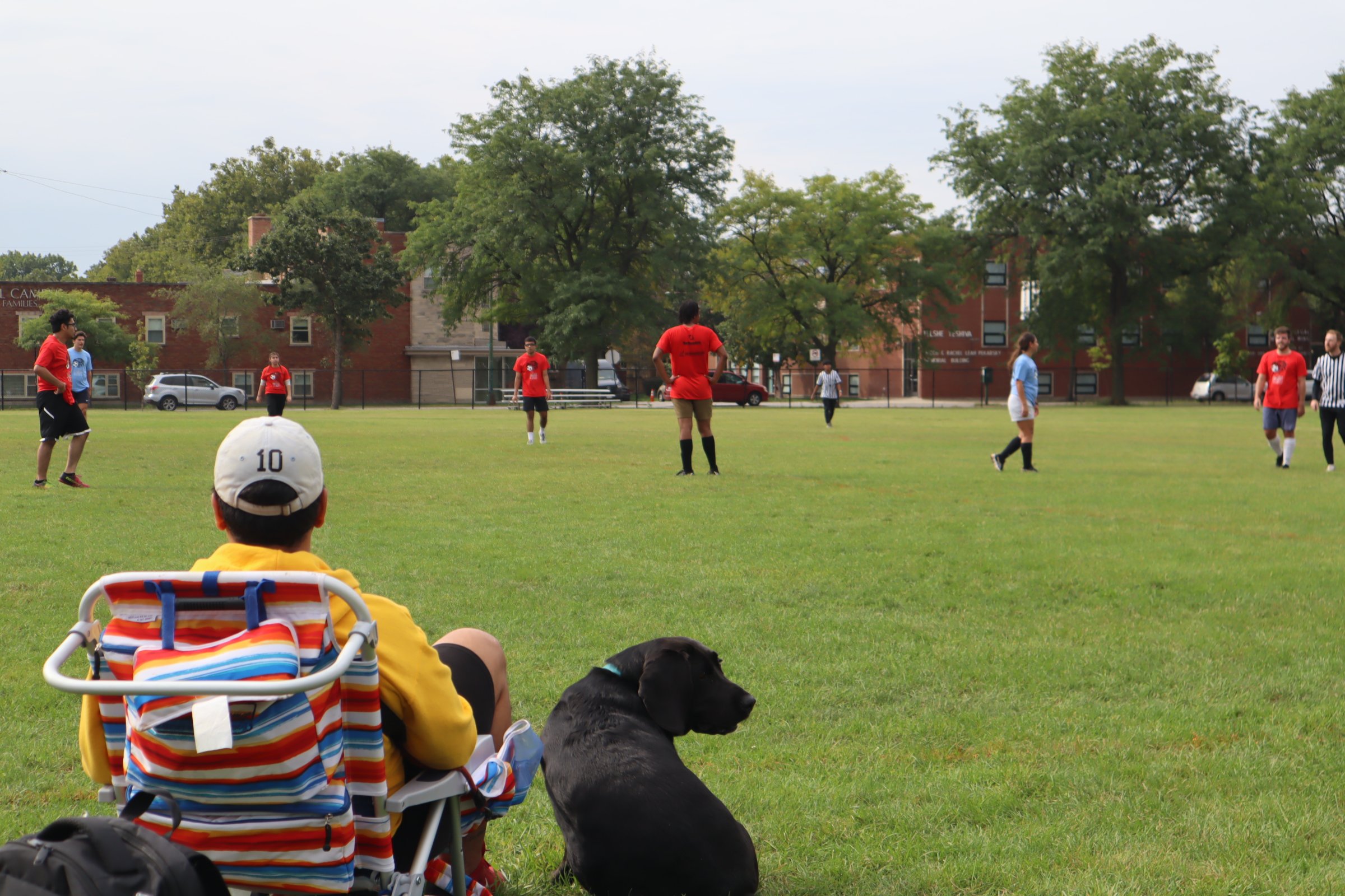 Community member and his dog watching soccer