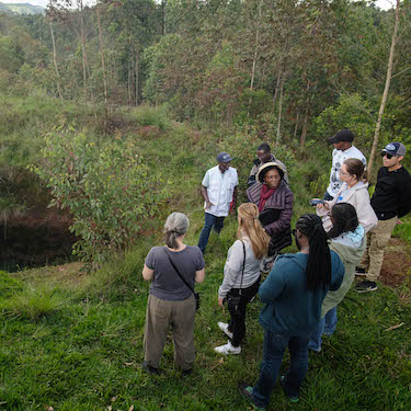 A photo of Jeanine Ntihirageza (group center) with Northeastern students, faculty and staff near a mass grave in Burundi during a study abroad trip in December 2023. Photo by Viktor Gerasimovski.