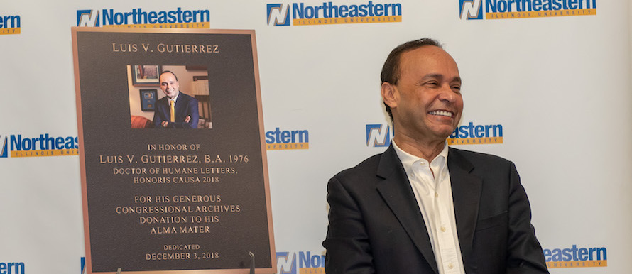 Luis Gutierrez smiles in front of the mock-up of his plaque.