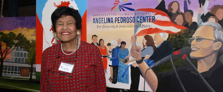 Dr. Angelina Pedroso smiles while standing in front of a sign for the Pedroso Center.